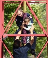 A man and a child stand together on top of a tower